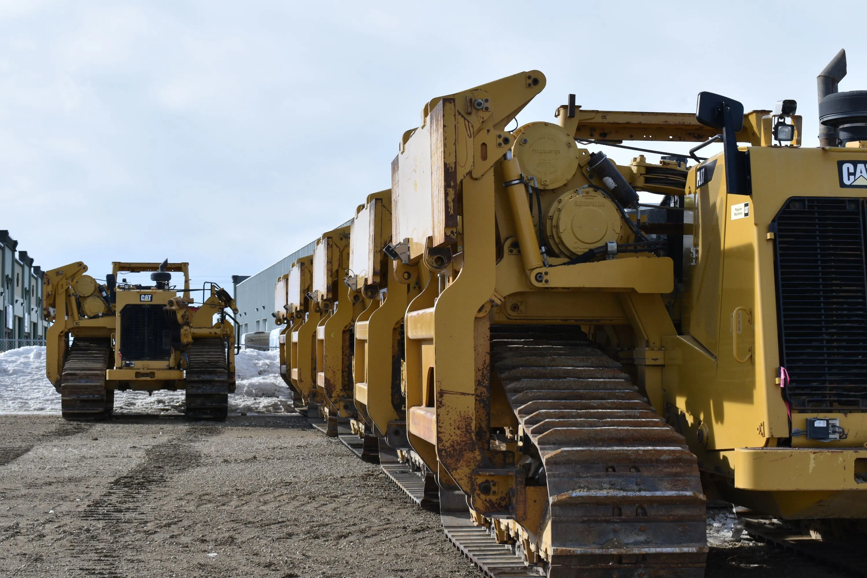 Close up of 5 pipelayer machines in a row with an additional one to the left